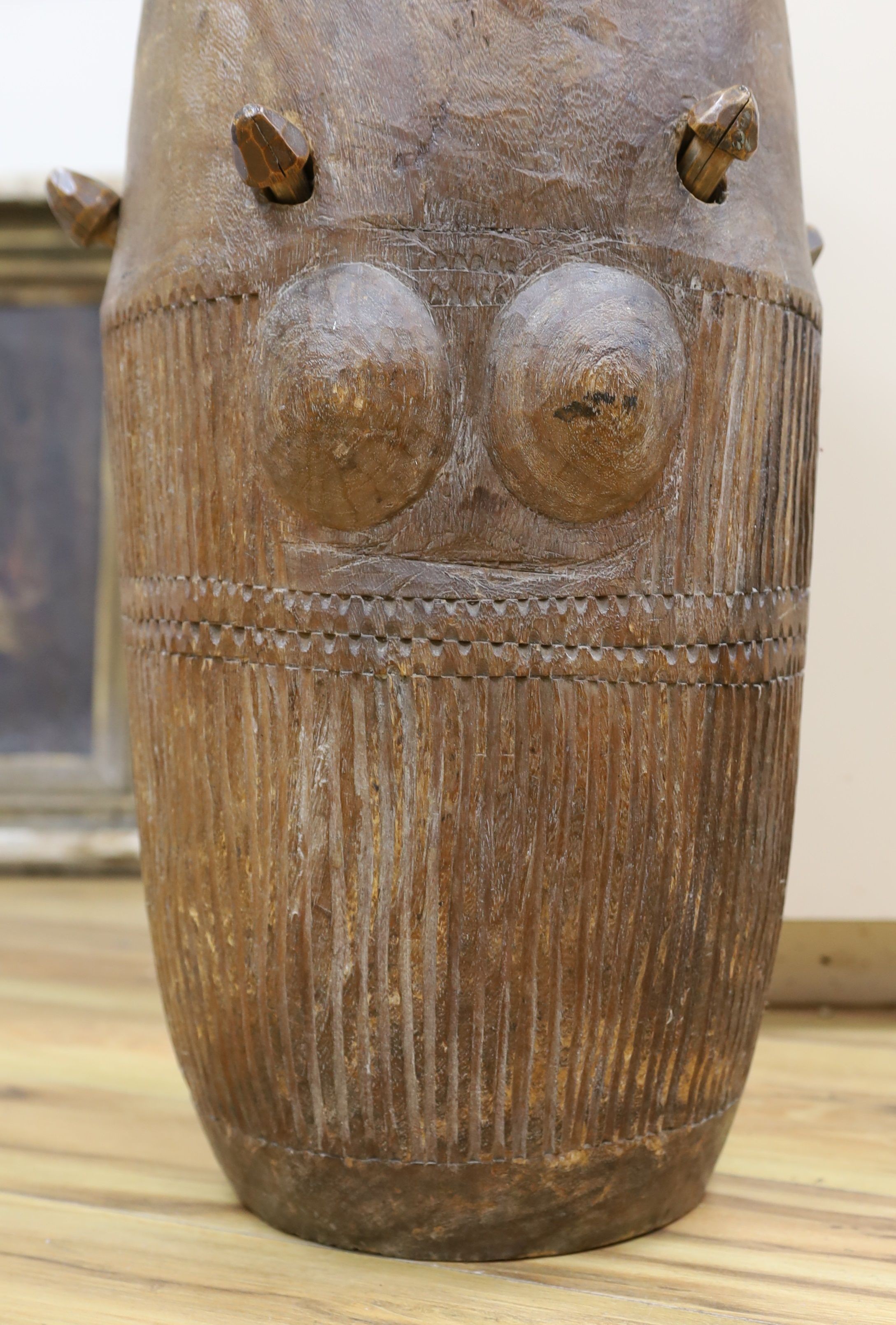 A 19th/20th century Ashanti breasted drum, 61 cms high.